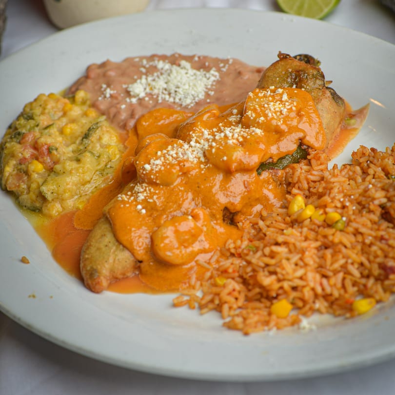 La Olla Mexican Cafe's chile relleno with red sauce, rice, refried beans, and corn.